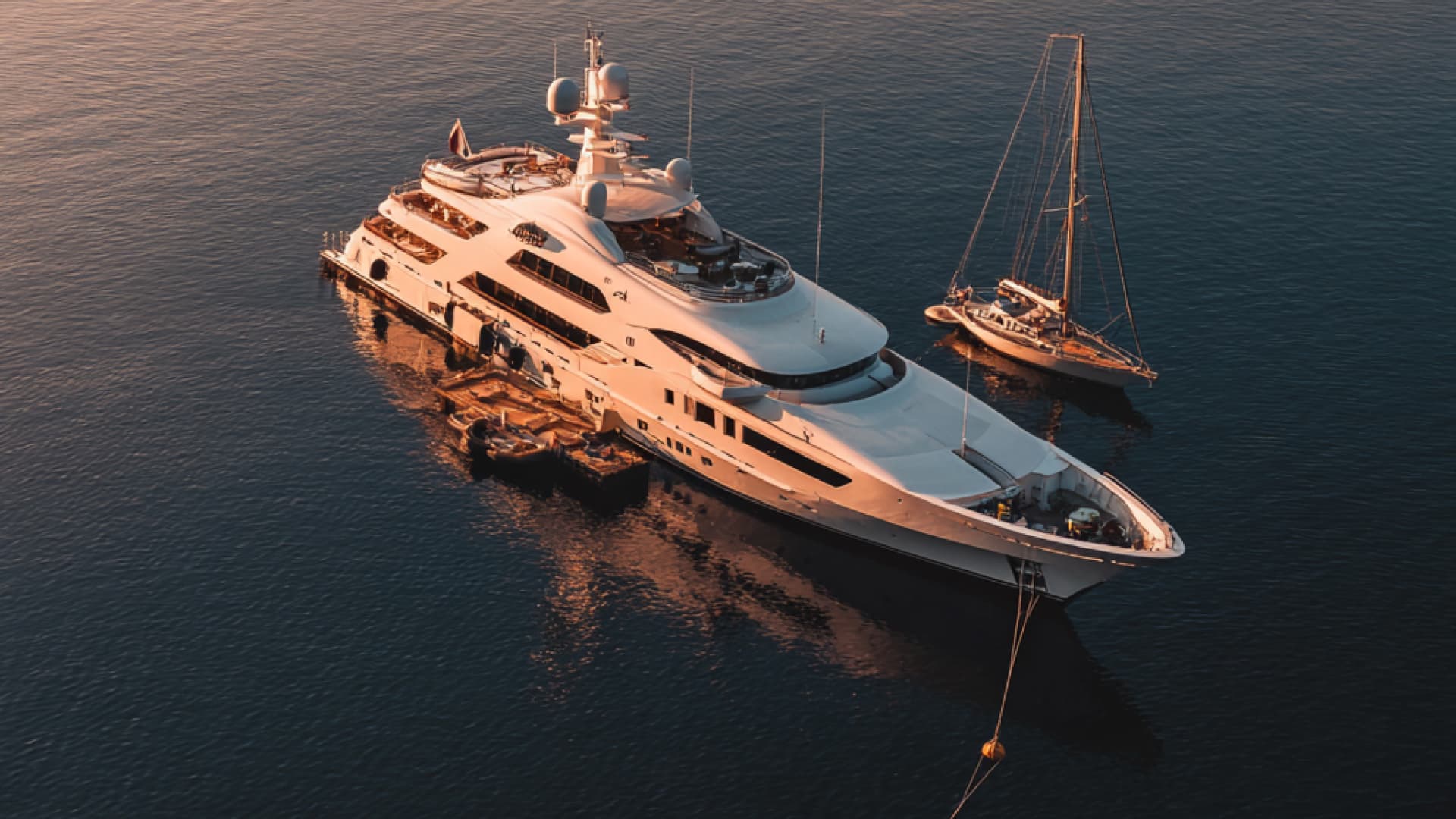 Superyachts moored in Monaco's Port Hercule — the most prestigious yacht berths in the Mediterranean with the principality's skyline behind